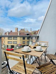 a table on a balcony with a view of a city at Duplex au cœur de Béthune 3 étoiles in Béthune