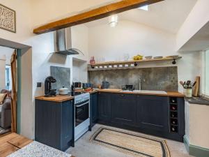 a large kitchen with black cabinets and a sink at 2 Bed in Bethesda 86740 in Llanddeiniolen