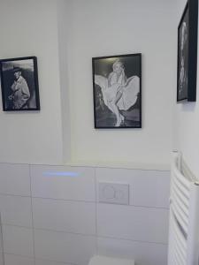 three pictures on a white wall in a bathroom at Schinderhannes in Waibstadt