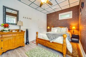 1 dormitorio con cama de madera y pared de ladrillo en Quaint Mt Vernon Cottage Near Historic Dtwn!, en Mount Vernon