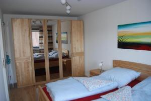 1 dormitorio con 2 camas y espejo en Ferienwohnung mit Balkon in Hohegeiß, en Braunlage