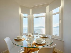 a dining room with a glass table with chairs and windows at 2 Bed in Cove 87473 in Cove