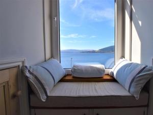 asiento junto a la ventana con almohadas y vistas al agua en 2 Bed in Cove 87473, en Cove