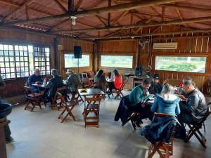 a group of people sitting at tables in a restaurant at Fazenda Serramar in Palhoça