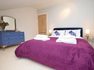 Cama púrpura con manta púrpura y cómoda azul en 2 Bed in Cove 87473, en Cove