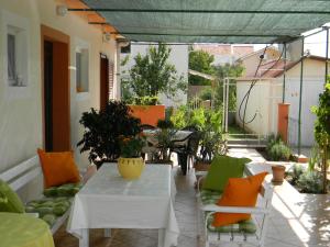un patio al aire libre con una mesa y sillas blancas en Apartments Gabriel, en Nin