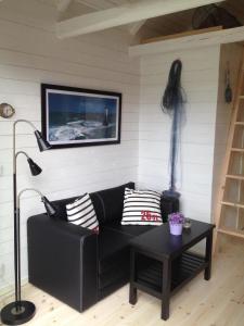 een woonkamer met een zwarte bank en een tafel bij Ferienhaus in Drag mit Möblierter Terrasse in Rockneby