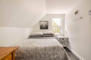 biała sypialnia z łóżkiem i oknem w obiekcie Un Havre de Bonheur w mieście Saint Adolphe D'Howard
