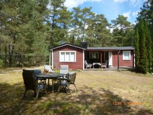 a small red house with a table and chairs at Ferienhaus in Yngsjö wenige Schritte zum Meer in Yngsjö