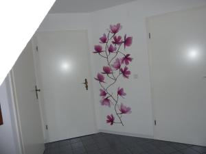 Una pared con un mural de flores púrpura. en Große Ferienwohnung in Bad Fallingbostel mit Garten, Grill und Terrasse en Bad Fallingbostel