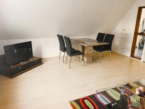 uma sala de jantar com uma mesa e cadeiras e uma televisão em Große Ferienwohnung in Bad Fallingbostel mit Garten, Grill und Terrasse em Bad Fallingbostel