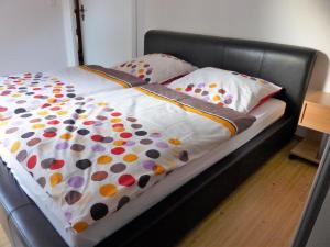 a bed with a black frame with polka dot sheets and pillows at Große Ferienwohnung in Bad Fallingbostel mit Garten, Grill und Terrasse in Bad Fallingbostel