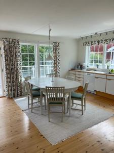 een eetkamer met een tafel en stoelen in een keuken bij Haus mit lichtdurchflutetem Wohnbereich auf einer kleinen Insel in Strömstad