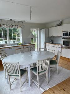 een keuken met een witte tafel en stoelen bij Haus mit lichtdurchflutetem Wohnbereich auf einer kleinen Insel in Strömstad