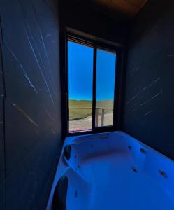 a bath tub in a room with a window at Pousada Campos da Serra in Bom Jardim da Serra