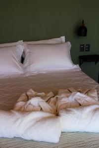 a bed with white sheets and blankets on it at Pousada Campos da Serra in Bom Jardim da Serra