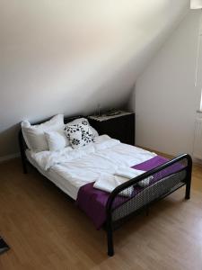 uma cama com lençóis brancos e almofadas num quarto em Ganzes Haus - 120qm Ruheoase bei Berlin S-Bahn nah em Kolonie Röntgental