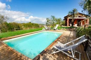 una piscina con 2 sillas y una casa en Ferienhaus mit Privatpool für 4 Personen ca 55 qm in Aiale, Toskana Provinz Pisa, en Lari
