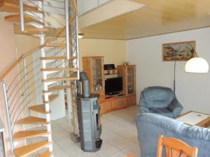 a spiral staircase in a living room with a blue couch at Ferienwohnung auf zwei Etagen, inmitten herrlicher Landschaft - b48738 in Pretzfeld