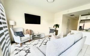 a living room with a couch and two chairs and a tv at Modern Townhouse with terrace! in Homestead