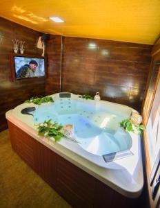 uma grande banheira num quarto com televisão em Ferienhaus in Laroya mit Whirlpool, gemeinschaftlichem Pool und Grill em Laroya