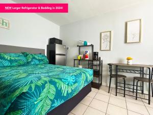 a bedroom with a bed and a table and a refrigerator at 2 Bed Cottage with Pool, Close to Beach! BBQ Grills & Patio in Fort Myers +22 photos