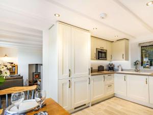 a kitchen with white cabinets and a table with wine glasses at 2 Bed in Fowey 86873 in Saint Veep