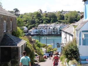 a group of people walking down a street with houses at 2 Bed in Fowey 86873 in Saint Veep