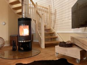a wood burning stove in a living room with a staircase at Nordkugel - Kugelhaus am See in Penzlin