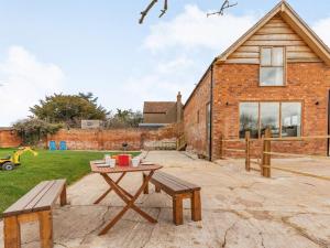 a patio with a table and benches in front of a brick building at 3 Bed in Eckington 86760 in Eckington