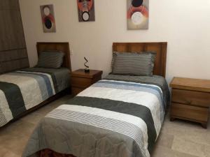 a bedroom with two beds and a night stand at Renta en San Miguel De Allende in San Miguel de Allende