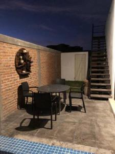a patio with a table and chairs next to a brick wall at Renta en San Miguel De Allende in San Miguel de Allende