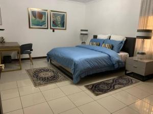 a bedroom with a blue bed and a desk at Luxury House near to Juan Sant. Airport, Alajuela. in Alajuela City +17 photos