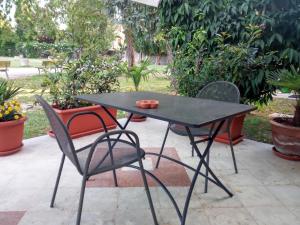 een zwarte tafel en stoelen op een patio bij Romantisches Gästezimmer 22 qm für max zwei Personen in Mira