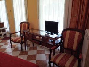 een woonkamer met een tafel met een televisie en 2 stoelen bij Romantisches Gästezimmer 22 qm für max zwei Personen in Mira