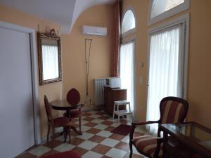 een woonkamer met een tafel, stoelen en ramen bij Romantisches Gästezimmer 22 qm für max zwei Personen in Mira