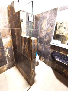 y baño con ducha, espejo y aseo. en Hotel Los Algarrobos, en Puerto Baquerizo Moreno