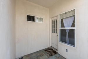 オーシャンサイドにあるOceanside Private Beautiful Beachside Guest Suiteの窓とドアが付いた空の部屋