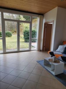 a living room with sliding glass doors and a couch at Haus Talblick, am Waldrand in Solnhofen