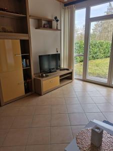 a living room with a tv and a large window at Haus Talblick, am Waldrand in Solnhofen