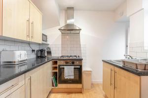 uma cozinha com fogão forno ao lado de um lavatório em Stunning Serviced Accommodation Near City Centre em Allesley