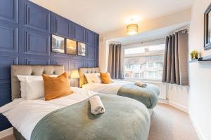 Duas camas num quarto com paredes azuis em Stunning Serviced Accommodation Near City Centre em Allesley