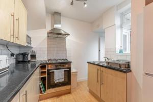a kitchen with a stove top oven next to a sink at Stunning Serviced Accommodation Near City Centre in Allesley