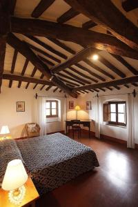1 dormitorio con 1 cama, 1 mesa y 2 ventanas en Casa Corzanello, en San Casciano in Val di Pesa