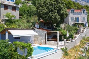 eine Villa mit einem Pool und einem Haus in der Unterkunft Ferienhaus mit Privatpool für 6 Personen ca 120 m in Baska Voda, Dalmatien Mitteldalmatien in Baška Voda