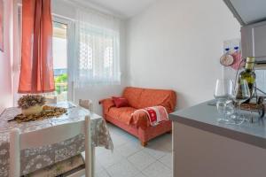 een woonkamer met een oranje bank en een tafel bij Apartments with a parking space Lopar, Rab - 18388 in Lopar