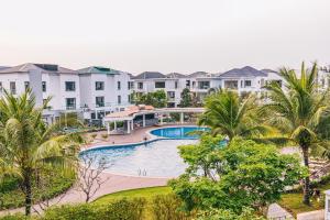 an aerial view of a resort with a swimming pool and palm trees at VILLA SB123 FLC SẦM SƠN in Sầm Sơn
