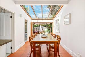 a dining room with a table and chairs and a skylight at Heritage Charm in Manly's Sun-Drenched Paradise in Sydney