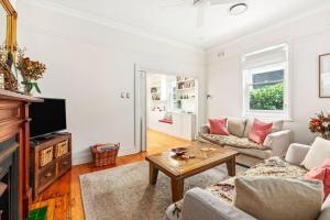 a living room with a couch and a table at Heritage Charm in Manly's Sun-Drenched Paradise in Sydney