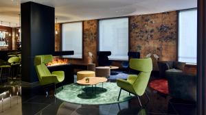 a lobby with green chairs and a fireplace at Hotel MyPalace León in León